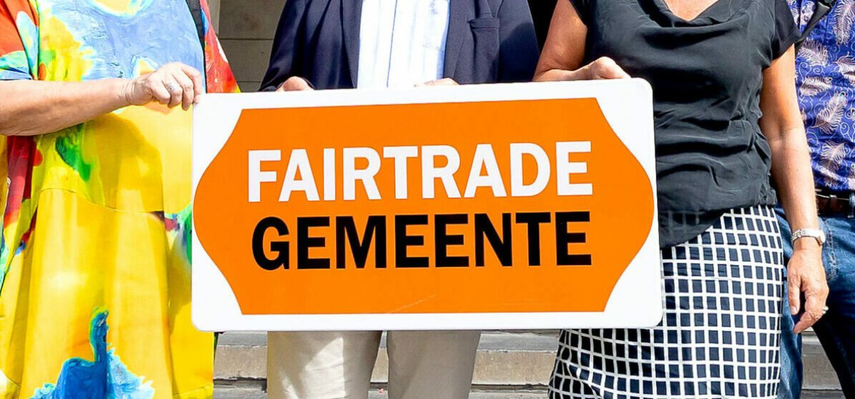 Wethouder Chantal Zeegers ontvangt van werkgroepleden van Stichting Fairtrade Rotterdam een cadeau wegens 10 jaar Rotterdam Fairtrade Gemeente. Tevens reiken de werkgroepleden haar symbolisch een bord aan met de tekst Fairtrade Gemeente. Foto Bart Hoogveld